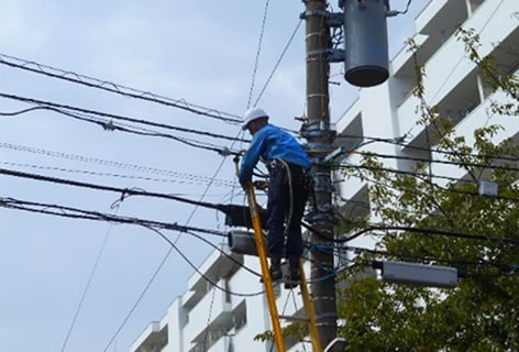 ハシゴで電線作業中